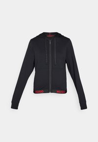 Zwarte zip-up hoodie met trekkoorden, voorzien van een geribbelde onderrand met rode "HUGO" branding, lange mouwen en een gladde stofstructuur.