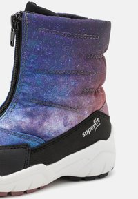 Botte d'hiver avec motif galaxie violet et bleu, base noire, fermeture éclair et semelle extérieure blanche. Matériau solide et accents texturés.