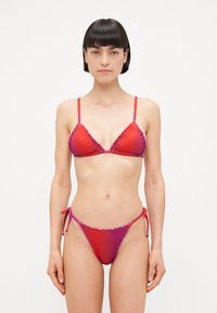 Bikini u gradijentu crvene i ružičaste boje s trokutastim šalicama i nabranim rubovima. Donji dio ima naglašene vezice sa strane za prilagodljivo pristajanje. Glatka tekstura.