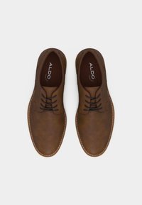 Chaussures à lacets en cuir marron avec bouts arrondis, coutures visibles sur les semelles, et semelles intérieures marquées "ALDO Pillow Walk".