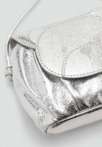 Srebrna usnjena torbica z teksturirano površino, okroglo obliko, zapiranjem na preklop in z majhnim embosiranim obraza medvedka na sprednji strani.