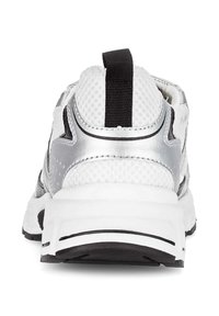 Witte sportieve schoen met een zilveren accent, bovenwerk van mesh en een gestructureerde hak. Inclusief een zwarte trekband en een zwarte rubberen zool.