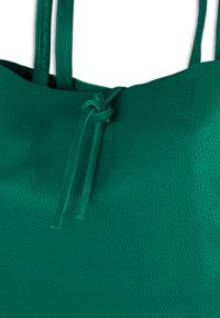 Groene leren totebag met lange bandjes en een geknoopt sluitingsdetail. Glad oppervlak met een korrelig effect.