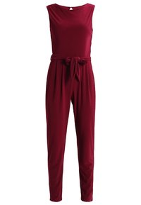 Combinaison rouge profond sans manches, avec encolure ronde, taille plissée, jambes fuselées et ceinture en tissu nouée en nœud à l'avant.