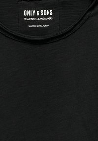 Czarna koszulka z okrągłym dekoltem, miękka w dotyku, z widoczną metką z logo "ONLY & SONS" oraz informacjami o pielęgnacji.