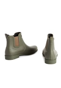 Bottes en caoutchouc vertes pour les chevilles avec des panneaux latéraux élastiques, des accents en tissu texturé, des semelles en caoutchouc plates et un design épuré et élégant.