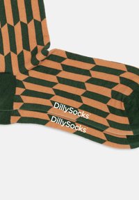 Grüne und beige gemusterte Socken mit geometrischem Design. Mit DillySocks-Logo in Weiß an der Seite. Weiches Strickmaterial.