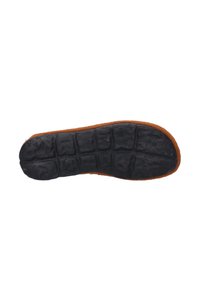Zool van een schoen met een getextureerde zwarte rubberen onderkant en een bruine fuzzy bovenrand, ontworpen voor comfort en grip.