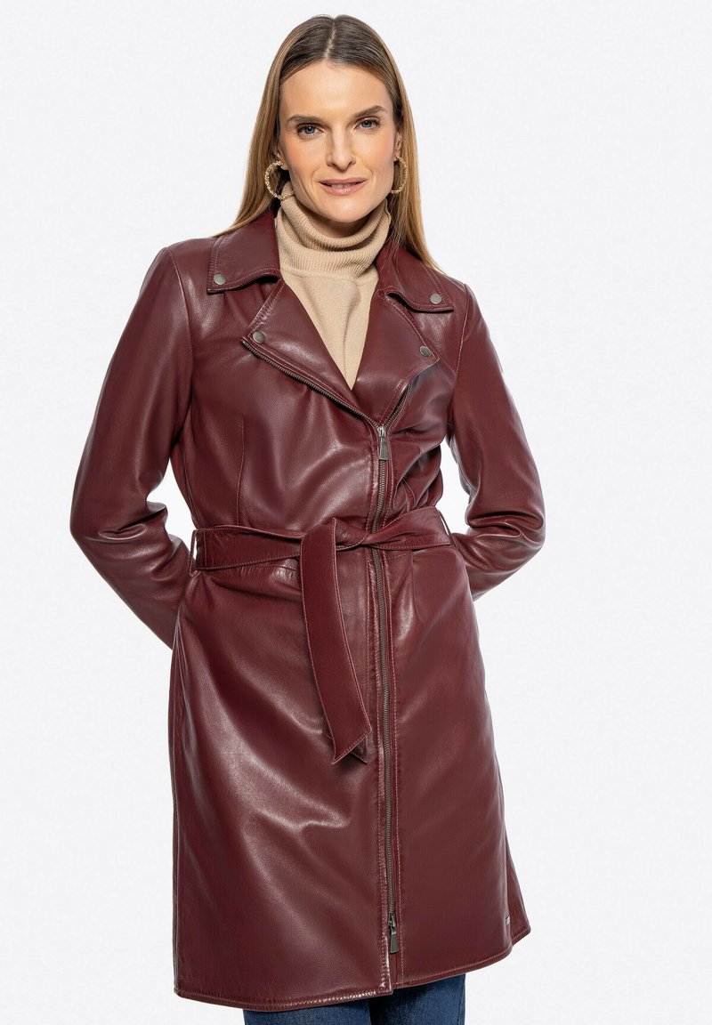 Cappotto in pelle bordeaux con vita cinturata, colletto a punte e chiusura con zip. Presenta una texture liscia e un design aderente.