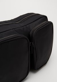 Monki Axelremsväska - black