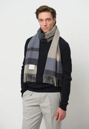Wollen sjaal van een wolmix met grijze, beige en marineblauwe strepen, met franjes aan de uiteinden en een geweven label aan de rand. Zachte textuur en rechthoekige vorm.