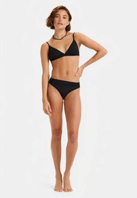 Black bikini set featuring a triangular top and ruched bottom. Smooth fabric with minimalistic design and adjustable straps.