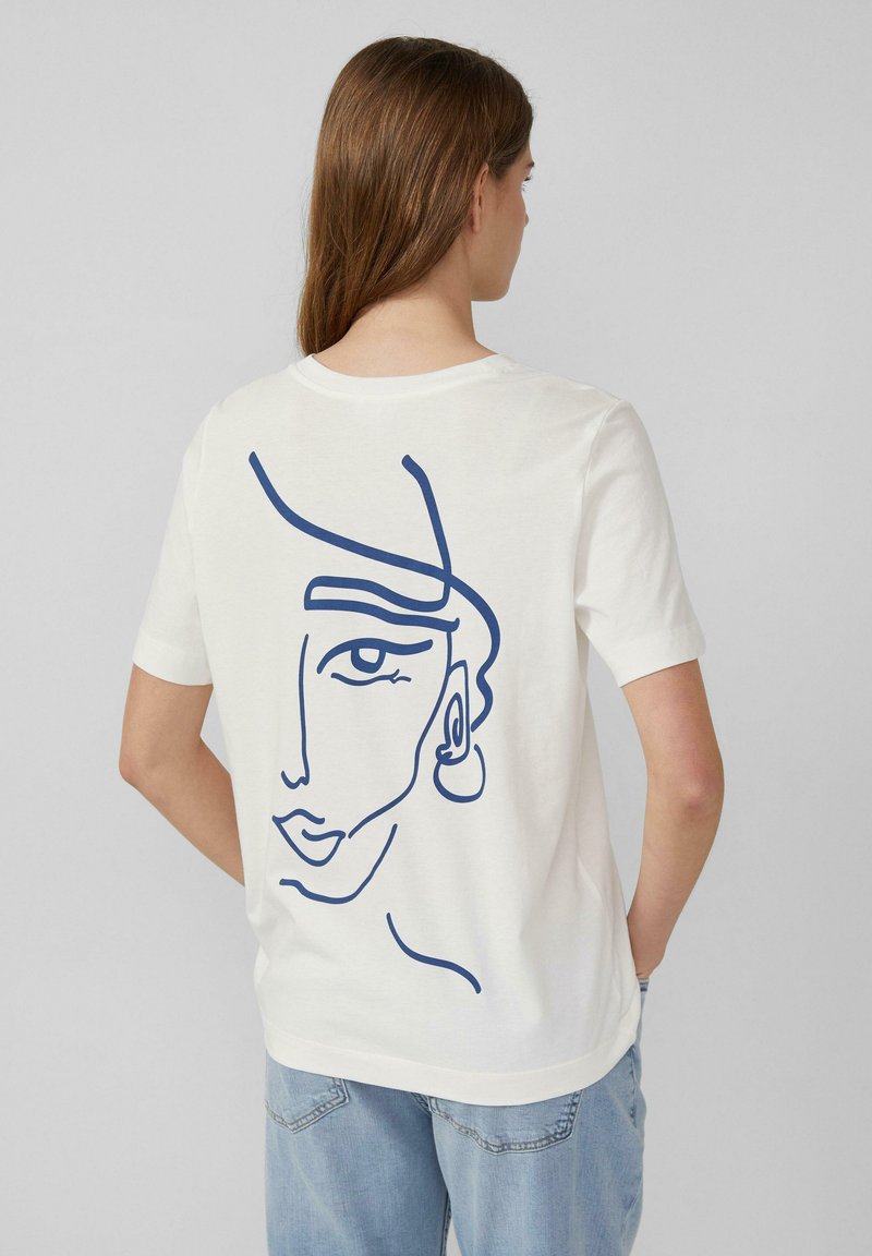 Witte T-shirt met een marineblauwe lijntekening van een gezicht op de achterkant. Korte mouwen en een ronde halslijn met een relaxte pasvorm.