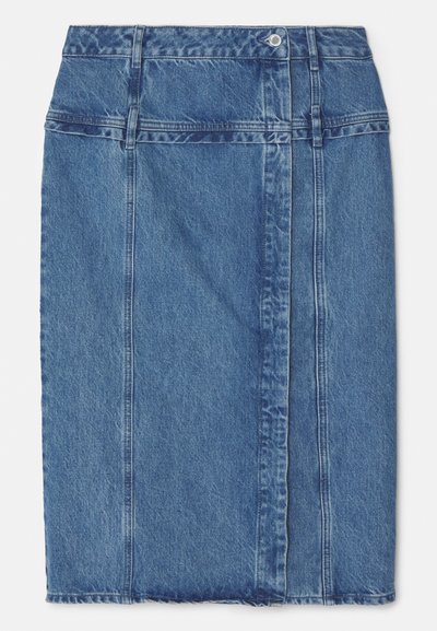 Τζιν μίνι φούστα σε μεσαίο μπλε χρώμα με λεία υφή, ακατέργαστο στρίφωμα και λεπτομέρειες ραφής μπροστά. Περιλαμβάνει κλασικό σχέδιο με πέντε τσέπες.