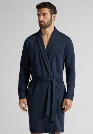 Navyblauer Bademantel aus weichem Stoff, mit Schalkragen, langen Ärmeln, einem Bindegürtel und einer Brusttasche.