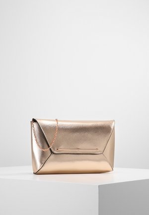 Metallic roségouden enveloppe clutch met een dunne kettingriem, gepositioneerd op een wit voetstuk tegen een effen achtergrond.
