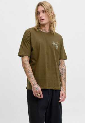 Olivenfarvet bomulds T-shirt med rund halsudskæring og korte ærmer. Har "Premium" trykt i hvidt på venstre brystområde. Løs pasform.