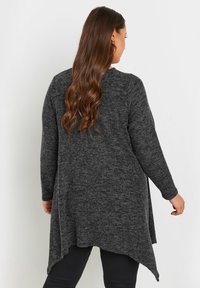 Długi rękaw, ciemnoszary kardigan z fakturowanej dzianiny, z asymetrycznym dołem i luźnym krojem.