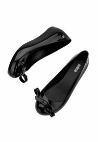 Ballerine nere in vernice con un'accento a fiocco sulla punta, texture liscia, forma arrotondata e design flessibile, facile da indossare.