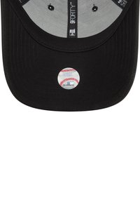 Fekete baseball sapka lapos brimmel, az alján egy ezüst kör alakú matricával, amelyen baseball grafika látható. Érzékelhető textúrájú anyag.