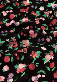 Bloemstof met rode, roze en paarse bloesems op een zwarte achtergrond; gladde textuur met een levendig, kleurrijk ontwerp.