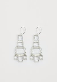 Skaidras kristāla pilienu auskari ar ģeometrisku dizainu, kas satur vairākus taisnstūra veidus un sudraba toņu detaļas. Teksturēta apdare.