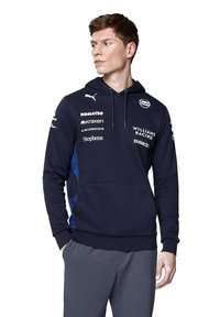 Granatowa bluza z kapturem, z ściągaczem i kieszenią z przodu, z niebieskimi akcentami po bokach oraz logo różnych sponsorów. Wykonana z miękkiego materiału.