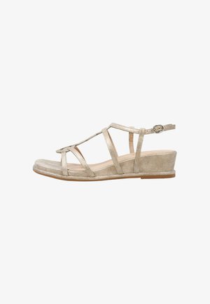 Sandale compensée en daim beige avec plusieurs fines lanières et boucle réglable à la cheville, semelle plate et design à bout ouvert.