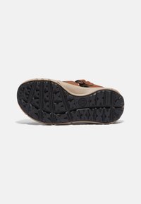 Bruna och beige sandaler med en strukturerad gummisula som har stjärnformade mönster för bättre grepp. Inkluderar ett band för en säker passform.