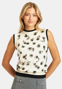 Top senza maniche di maglia crema con rifiniture nere, caratterizzato da applicazioni floreali in paillettes nei toni del argento e del nero per texture e dettagli.