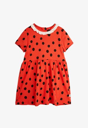 Sarkanais kleita ar melniem punktiņiem, īsām piedurknēm un baltu mežģīņu apkakli. Izplūdušais dizains ar savilkta jostas vietu un apakšmalu. Mīksta auduma.