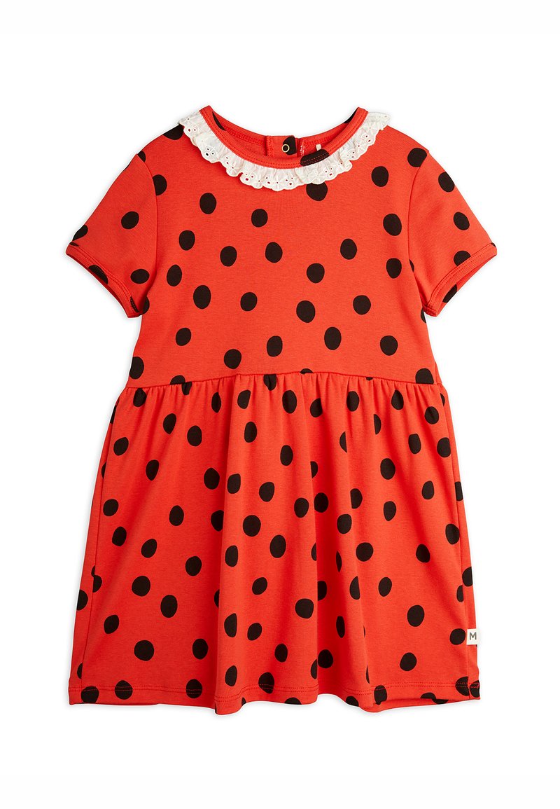 Robe rouge à pois noirs, à manches courtes, avec un col en dentelle blanche. Design évasé avec une taille froncée et un ourlet. Tissu doux.
