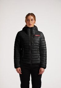 Giubbino nero imbottito con cappuccio, chiusura frontale con zip, texture trapuntata e logo rosso "JACKIT". Presenta zip a contrasto e tasche laterali.