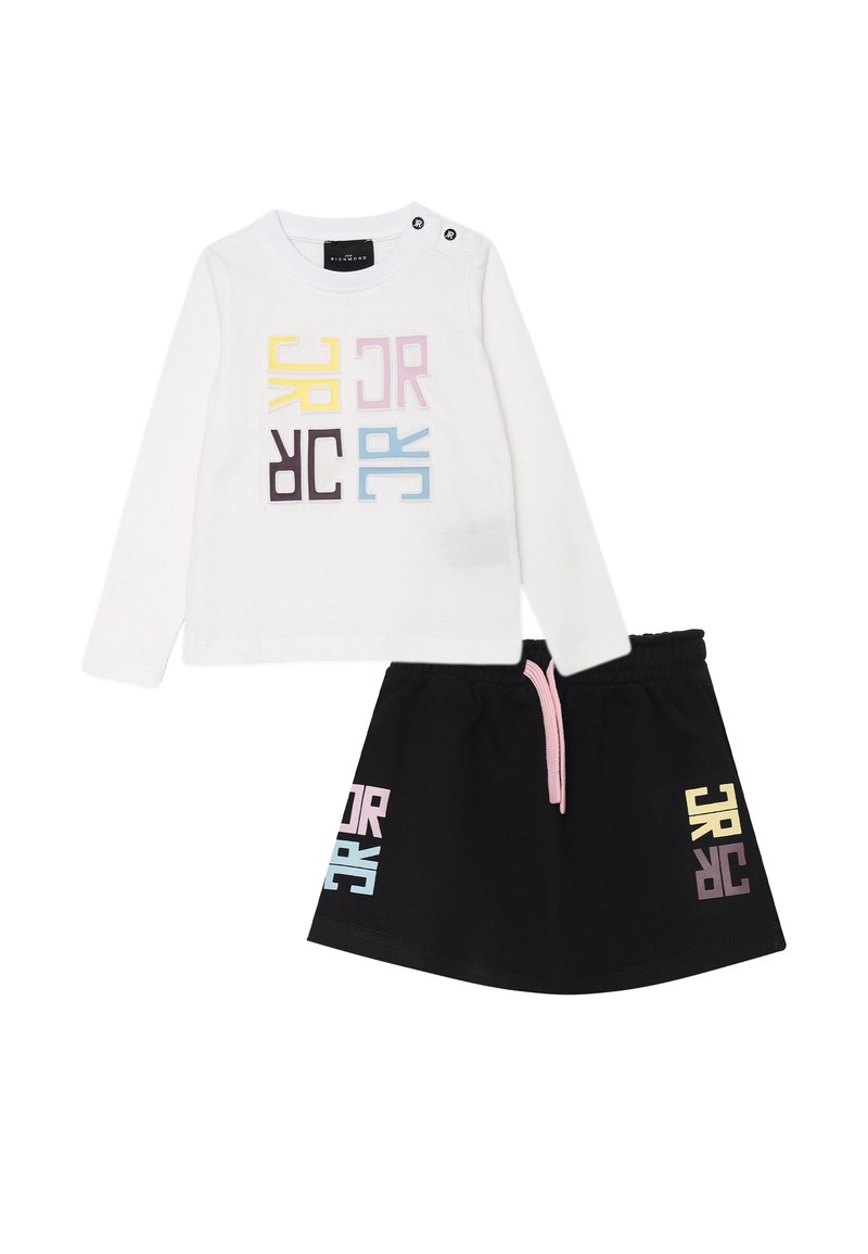 Camicia bianca in cotone a maniche lunghe con lettere colorate a blocchi; gonna nera in cotone con cordino rosa chiaro e vivaci accenti grafici.