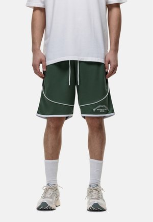Groene sportshorts met witte bies, een elastische tailleband en een logo op het linkerbeen. Draag met een wit shirt en lichte sneakers.