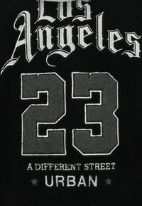 Zwarte fleece trui met witte en grijze geborduurde tekst: "Los Angeles," "23," "A Different Street," en "URBAN."