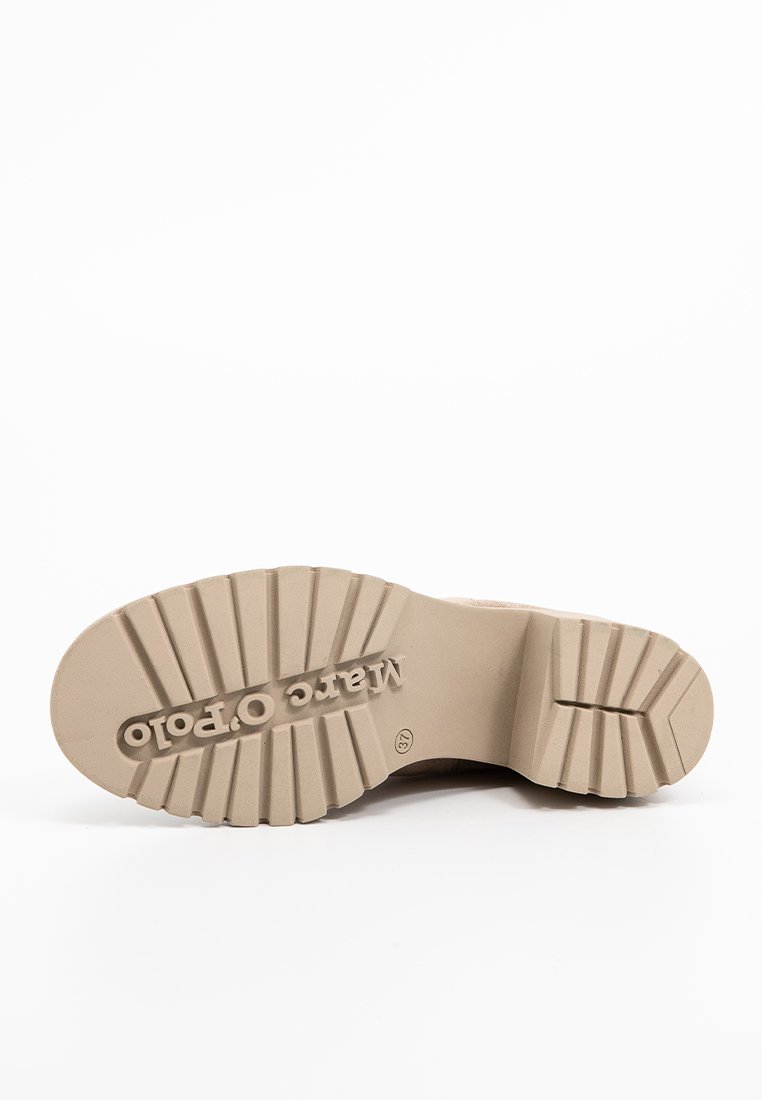 Beige Schuhsohle mit tiefen Rillen, flachem Absatz und eingeprägtem "Marco Polo"-Logo. Das Material scheint Gummi zu sein, mit strukturierten Oberflächen für besseren Halt.