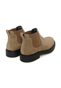 Rudos zomšos Chelsea batai su elastinėmis šoninėmis juostelėmis ir juodu guminiu padu. Ant nugaros yra išskirtinė silueto forma ir dvigubi užtrauktukai, skirti patogesniam užsidegimui.