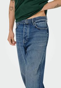 Ljusblå denimjeans med avslappnad passform, med en urtvättad textur, fem fickor och silverfärgad hårdvara vid midjan.