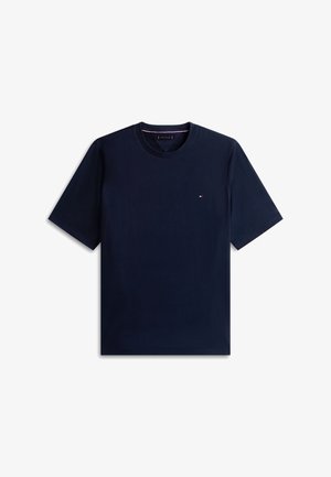 Camiseta de cuello redondo y manga corta color azul marino con pequeño logo rojo, blanco y azul en el lado izquierdo del pecho.