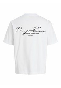 Bílý tričko s krátkým rukávem s černým kurzivním textem "Project Core" a tučným textem "Universal Standard" na zádech.