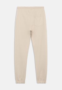 Beige cotton sweatpants with a drawstring waist, elastic cuffs, and a single back pocket for functionality. Smooth texture, simple design.