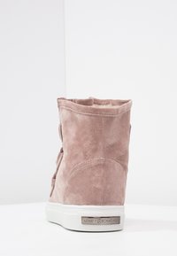 Stivale alla caviglia in suede rosa con finitura texturizzata, punta arrotondata e interno morbido, dotato di suola in gomma bianca e dettaglio con logo del brand.