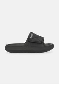 Black slide sandal featuring a textured rubber sole and a wide strap with a Velcro closure. The strap has a diamond pattern and logo detail.