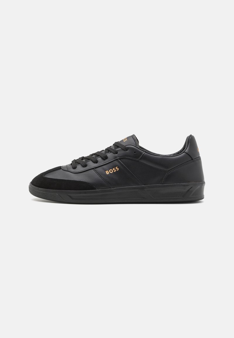 Baskets basses en cuir noir avec lacets noirs, semelle texturée et logo doré "BOSS" sur le côté et la languette.