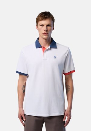 Polo a maniche corte di colore bianco, con colletto blu navy e polsini rossi. Presenta un piccolo logo sul petto e una vestibilità classica.