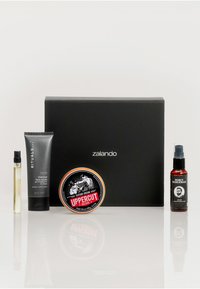 Czarny pudełko prezentowe z logo "zalando". Zawiera szklany flakon perfum, tubkę peelingu węglowego do twarzy, słoiczek kremu do tekstury oraz butelkę olejku do brody.