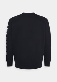 Schwarzer Baumwollpullover mit Rundhalsausschnitt, langen Ärmeln und weißen Textdetails, die entlang des linken Ärmels gedruckt sind. Glatte Textur.