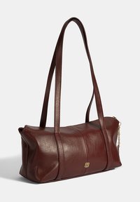 Burgunderfarbene Lederhandtasche mit zwei langen Tragegriffen, rechteckiger Form, feiner Textur und einem kleinen goldenen Emblem an der Seite.