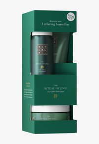 Grøn emballage med metalliske accenter, der indeholder tre runde beholdere mærket "The Ritual of Jing" med sølv- og guldbogstaver.